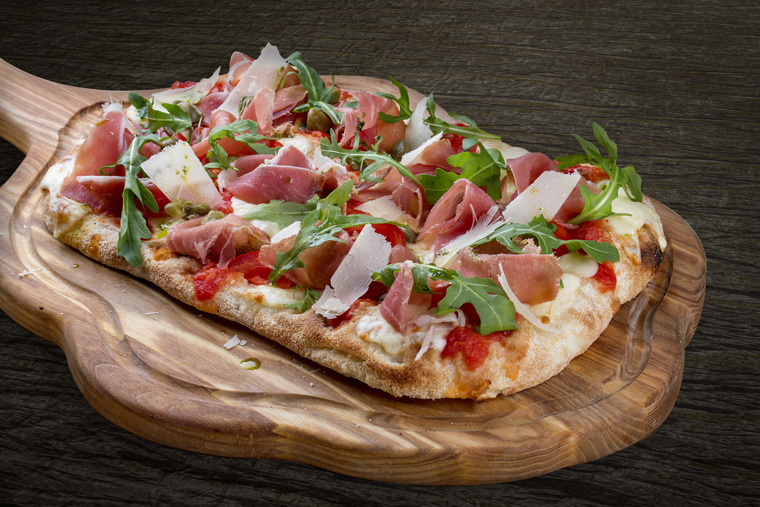 Sorrentina pizza with prosciutto, arugula, capers, pelati sauce,
